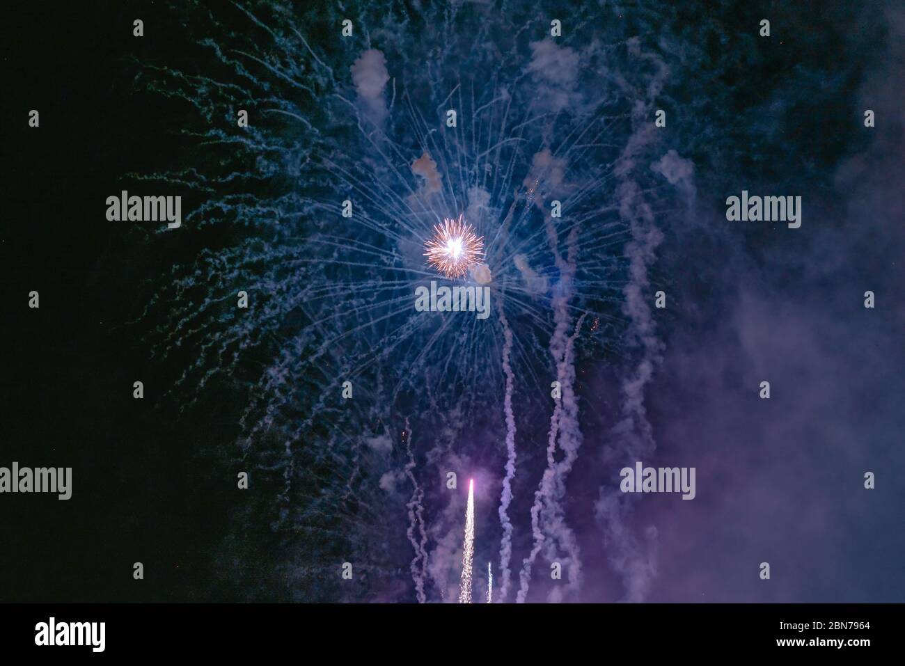 Blaues und gelbes Feuerwerk mit Rauch über dem schwarzen Himmel. Geringe Tastenbelichtung. Selektiver Fokus. Stockfoto