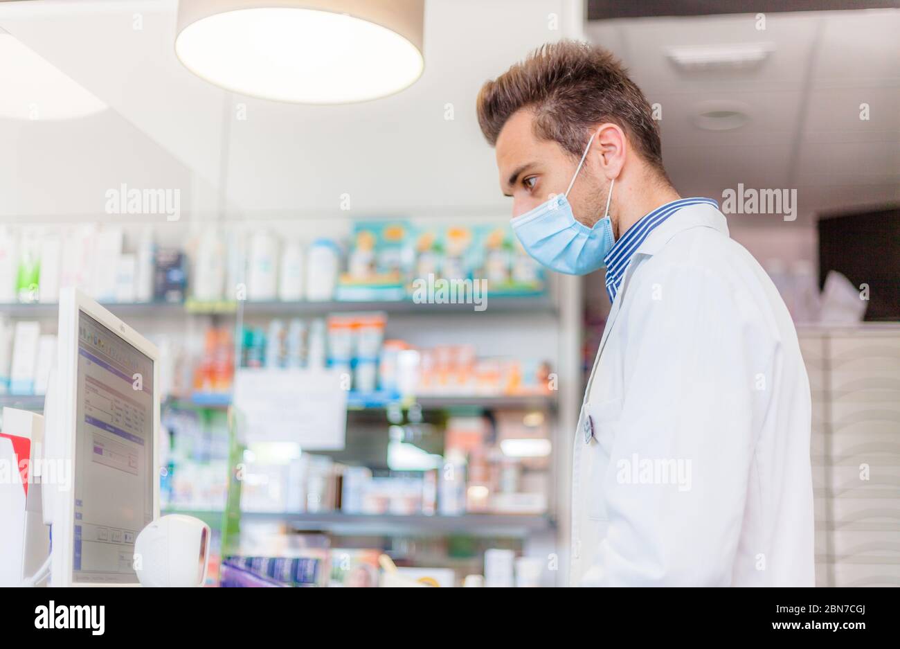 Apotheker, der Patienten mit einer Gesichtsmaske besucht Stockfoto