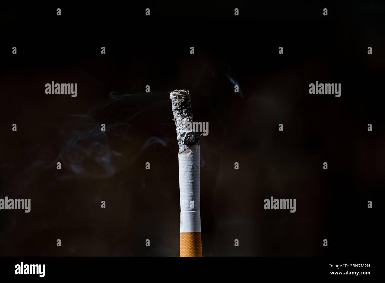 Isolierte brennende Zigarette, Tabakrauchsucht, ungesunde Lebensgefahr Stockfoto