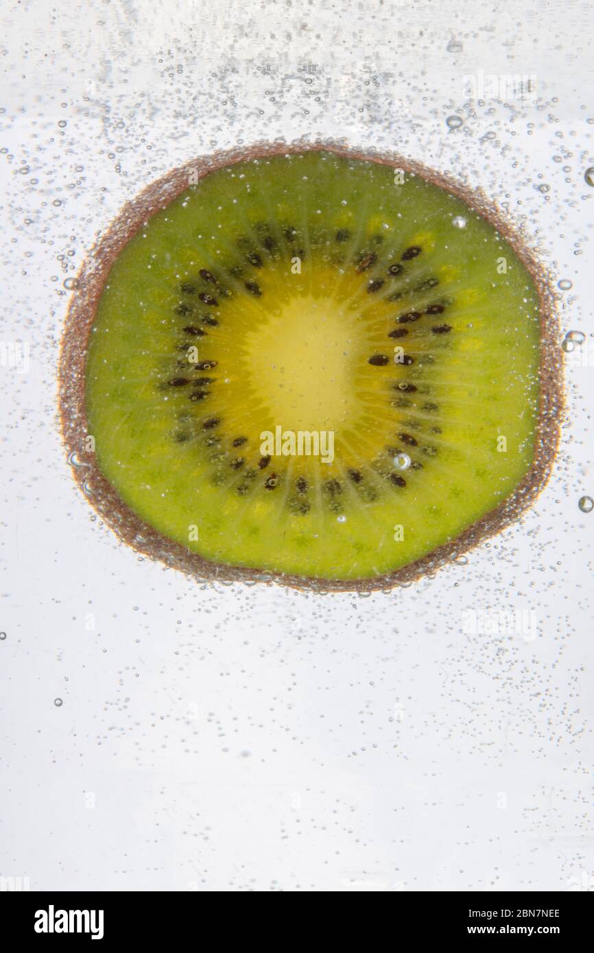 Ein erstaunlicher Schuss von einer Scheibe Kiwi-Frucht, die unter Wasser getaucht ist Stockfoto