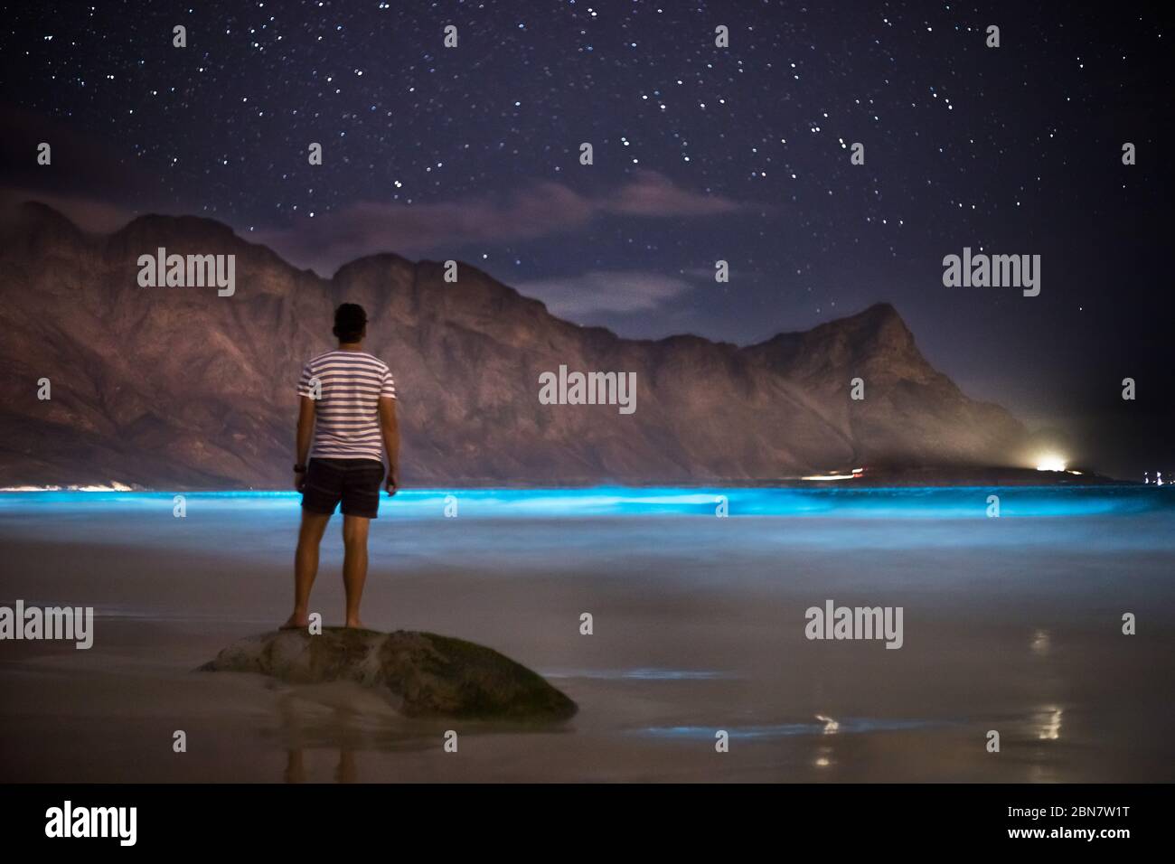 Biolumineszierende Plankton-Organismen im Wasser vor der Kogel Bay, Western Cape, Südafrika, geben ein blaues Leuchten ab, wenn die Wellenbewegung das Wasser aufrüttelt. Stockfoto