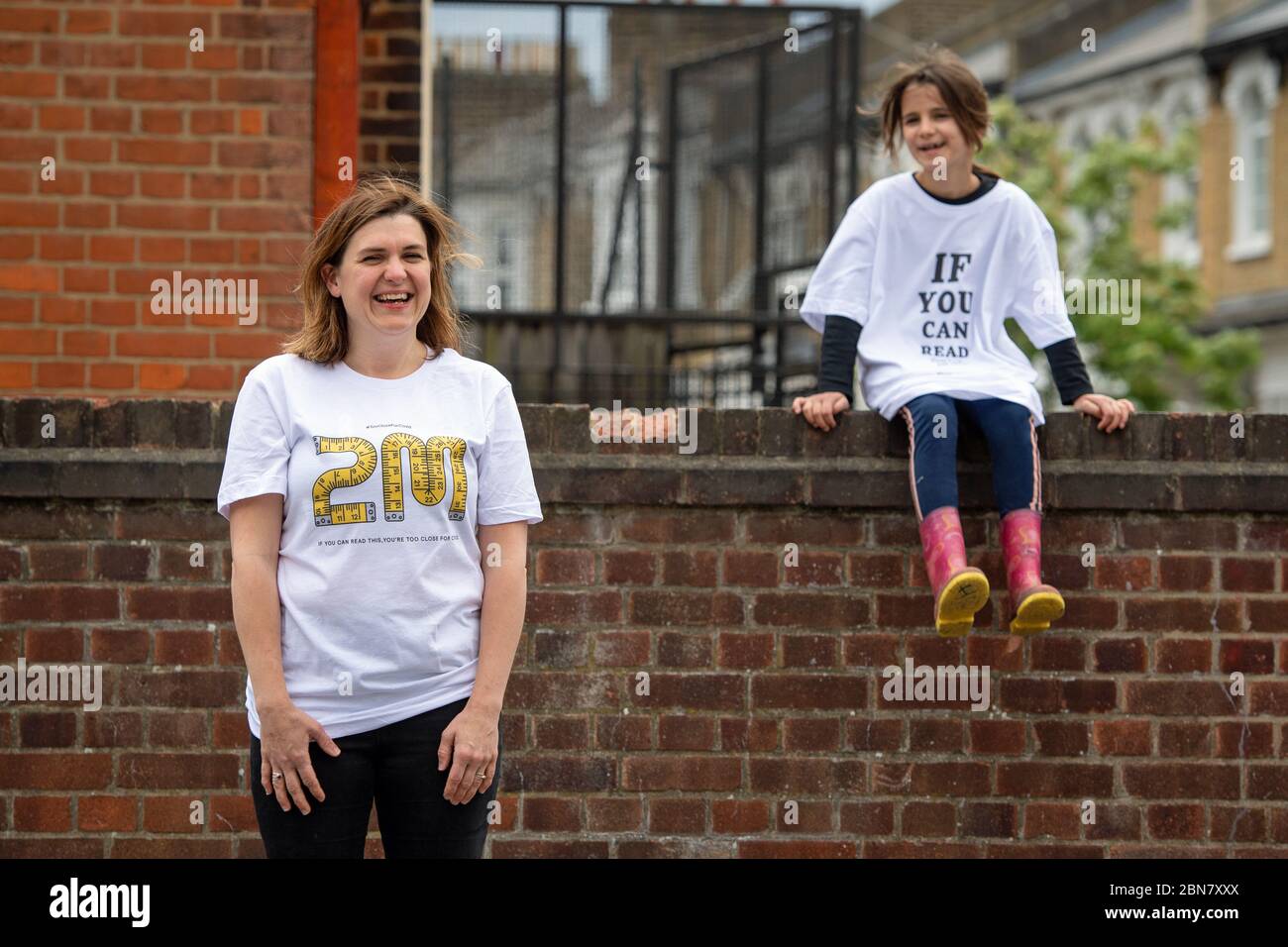 Nico und ihre Tochter Flori aus London tragen T-Shirts mit dem Slogan: „Wenn Sie dies lesen können, sind Sie zu nahe an COVID“, die vom globalen Unternehmen für die Markenumwandlung FutureBrand als gemeinnützige Initiative ins Leben gerufen wurden, um die wichtigsten Richtlinien für soziale Distanzierung zu stärken, während die Nation aus der Sperrung der Coronavirus-Pandemie herauskommt. Stockfoto