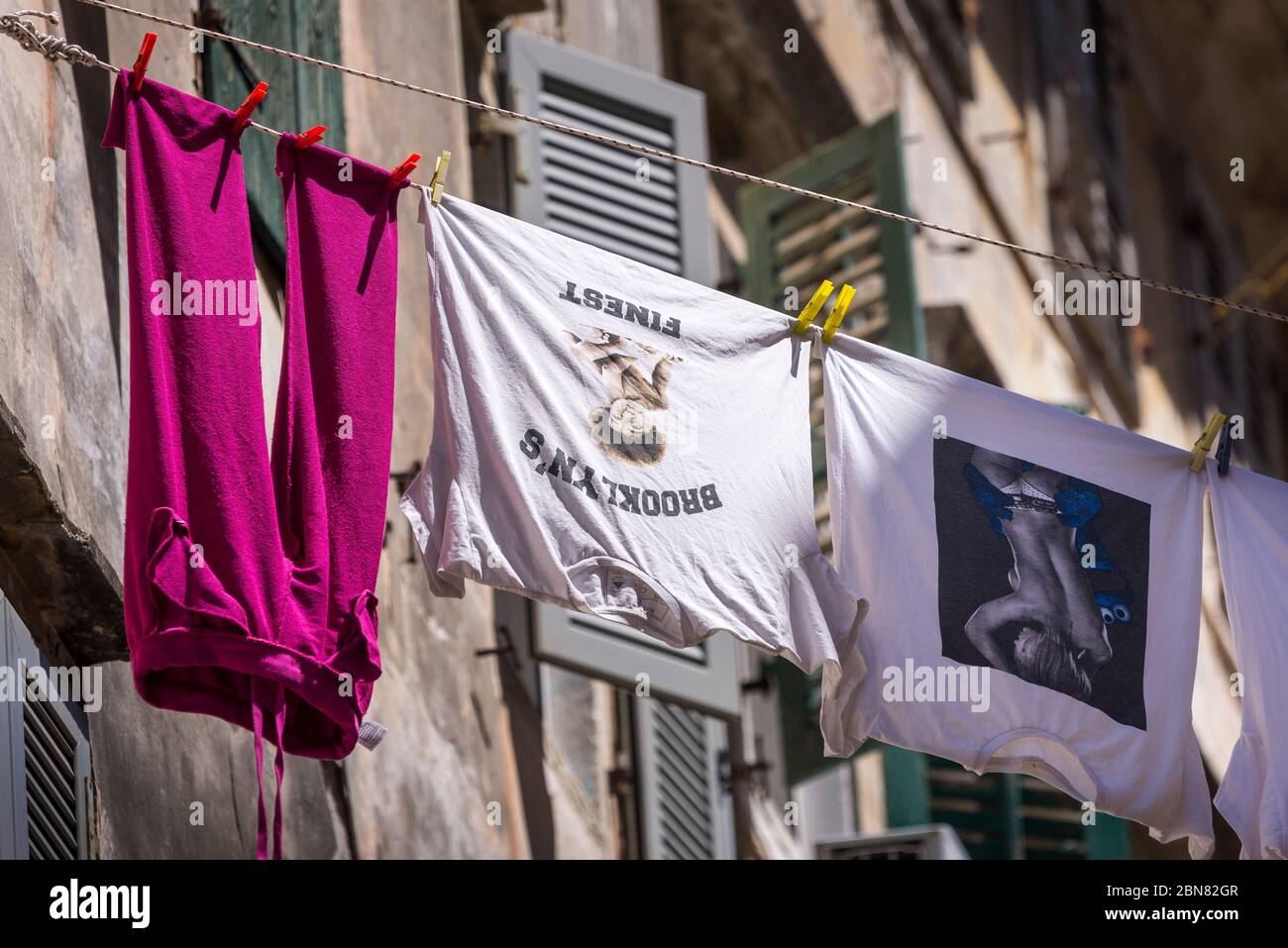 Bunte Wäsche, die zwischen den Gebäuden in Korfu, Griechenland, zum Trocknen hingen Stockfoto