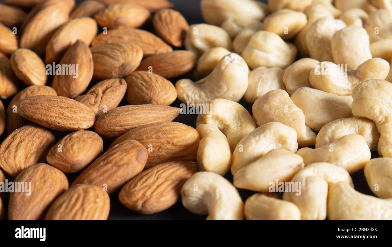 Bio geschälte Mandelnüsse und Cashewkerne als Hintergrund, Draufsicht. Gesunde Snacks. Verschiedene gesunde Nüsse Stockfoto