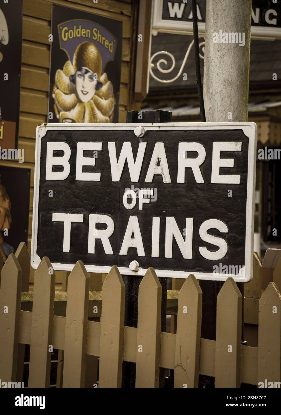 Nahaufnahme eines alten, emaillierten Eisenbahnschildes, das die Passagiere warnt: „Vorsicht vor Zügen“ am Bahnhof Heritage, Großbritannien. Stockfoto