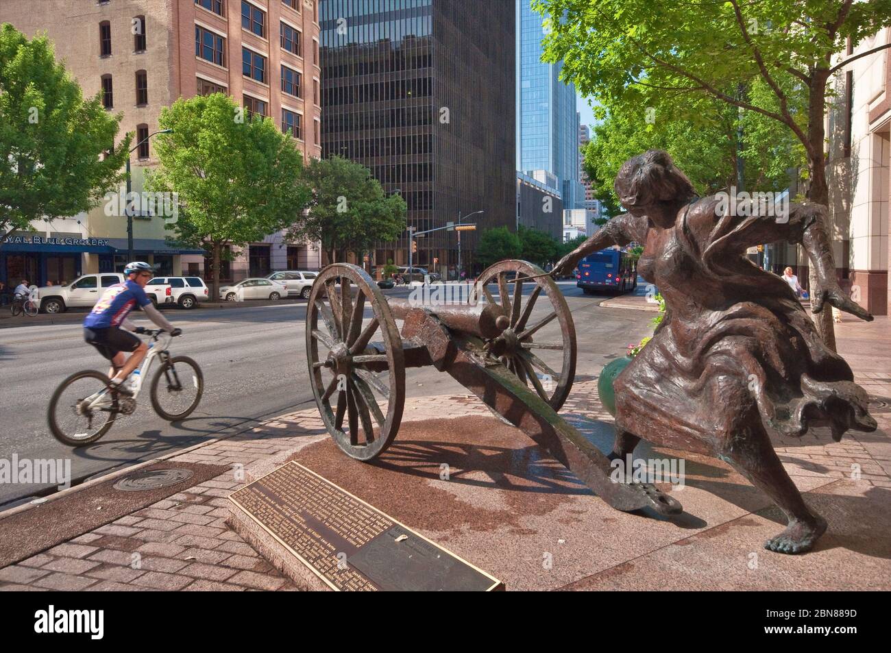 Radfahrerin, die Skulptur von Angelina Eberly, die eine Kanone feuert, beginnt Archives war von 1842, von Patrick Oliphant in der Congress Avenue, Austin, Texas Stockfoto