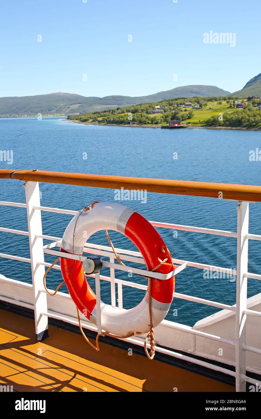 Deck eines Schiffs & Lebensrings, wie es Fjorde, Inseln und Innenpassagen kreuzt; der Andfjorden & Vestfjorden, zwischen Bodo & Hammerfest, Norwegen. Stockfoto