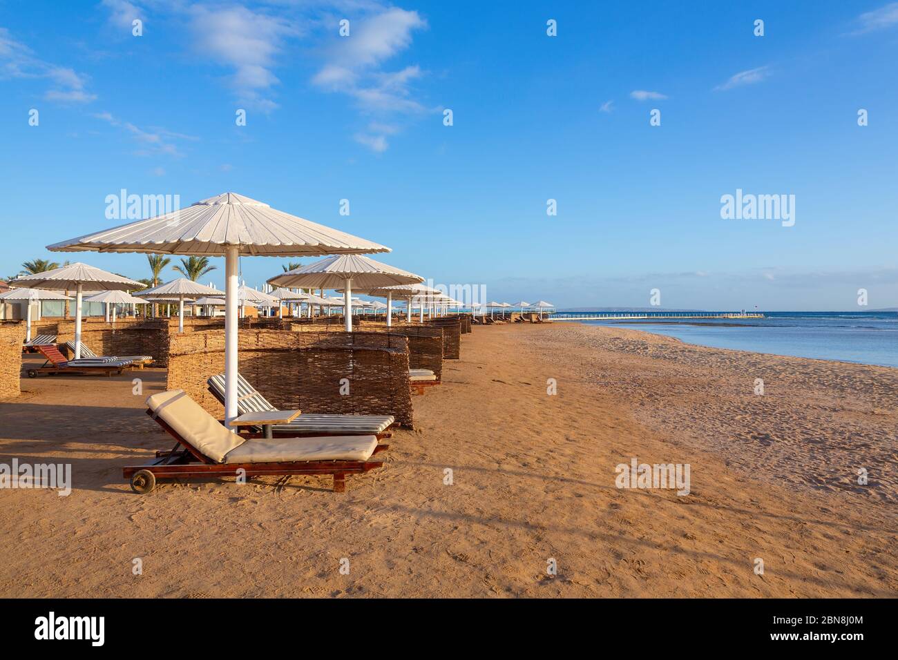 Ägyptische Küste mit Sonnenschirmen und Liegen am Strand in der Nähe des Roten Meeres Stockfoto Ägyptische Küste mit Sonnenschirmen und Liegen am Strand in der Nähe des Roten Meeres Stockfoto