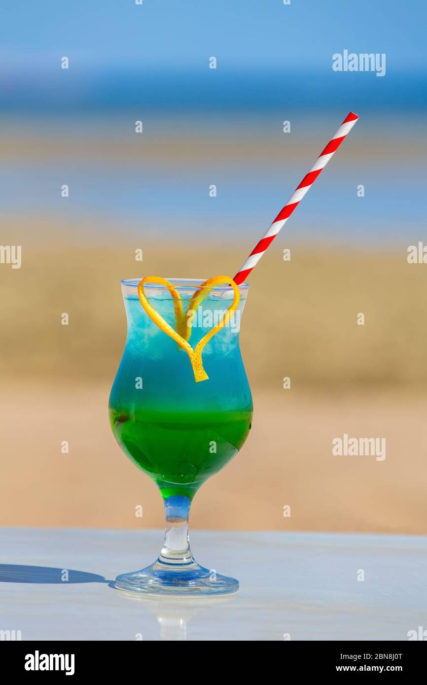 Farbenfroher Cocktail-Drink im Glas am Strand an sonnigen Tagen Stockfoto