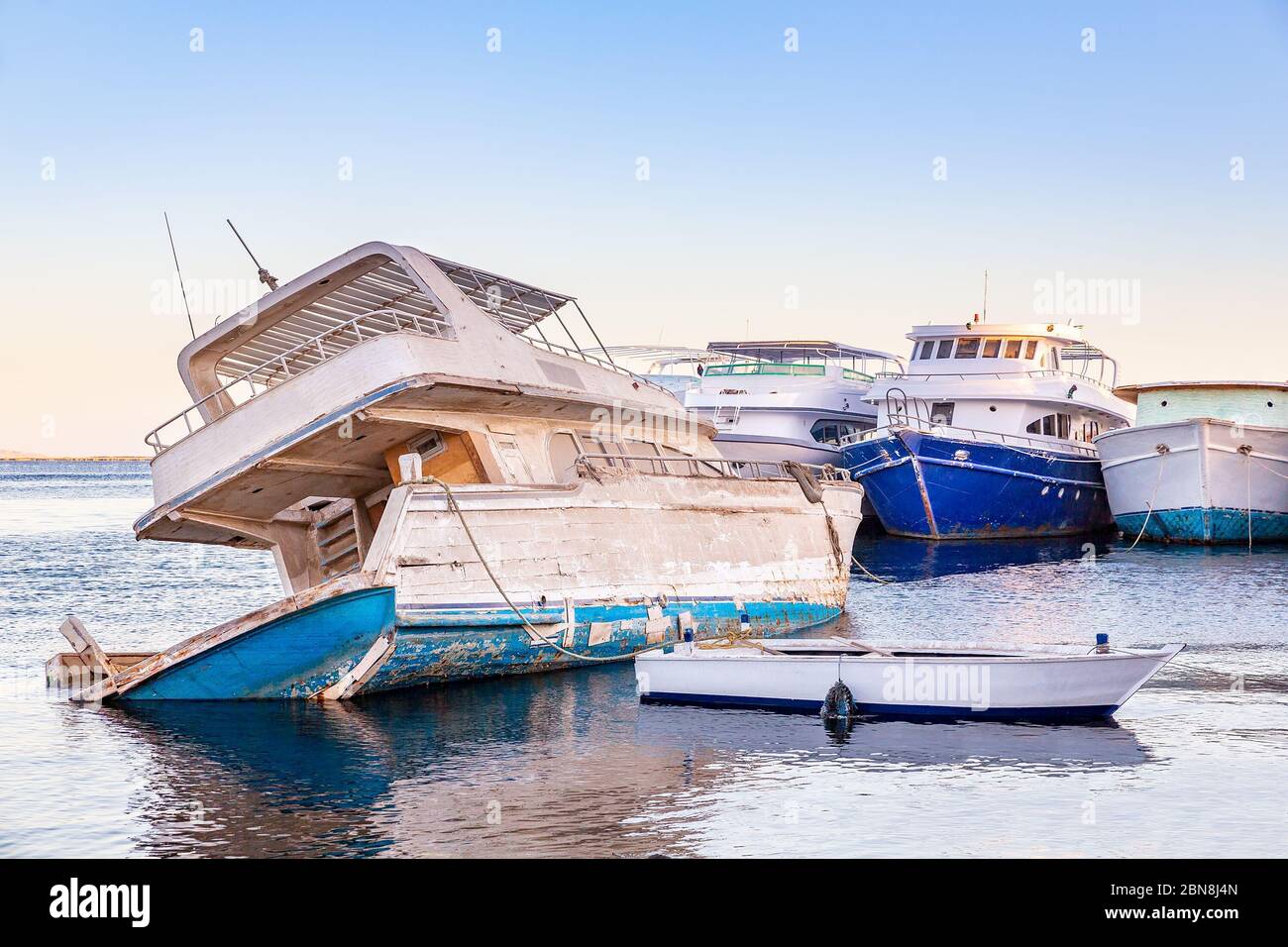 Altes hölzernes Vergnügungsboot auf dem Meer sinkt im Hafen Stockfoto