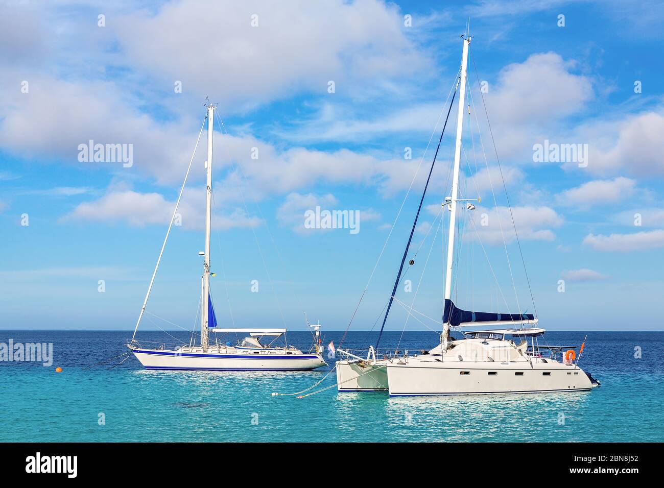 Zwei Segelboote, die auf blauem Wasser nahe der Küste von Bonaire schwimmen Stockfoto