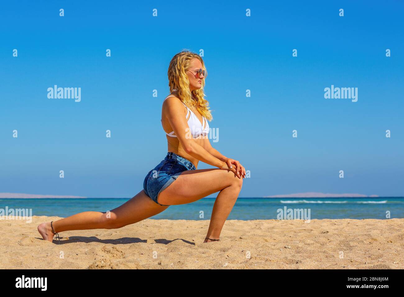 Junge europäerin in Yoga-Position am ägyptischen Strand Stockfoto
