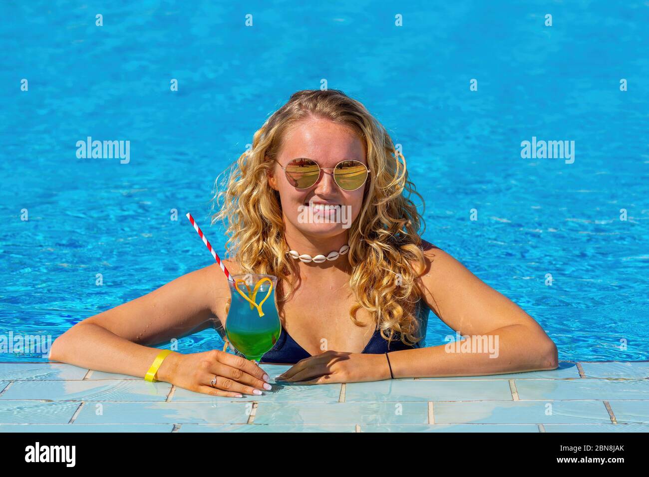 Junge holländerin mit Cocktail-Drink im Schwimmbad Stockfoto