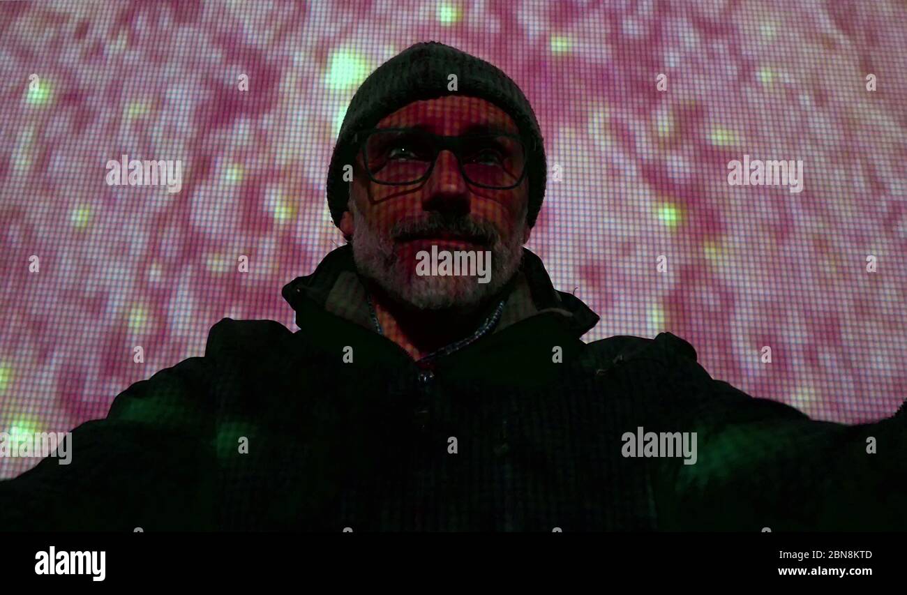 Videoprojektion über einen reifen Betrachter in einer dunklen Halle Stockfoto