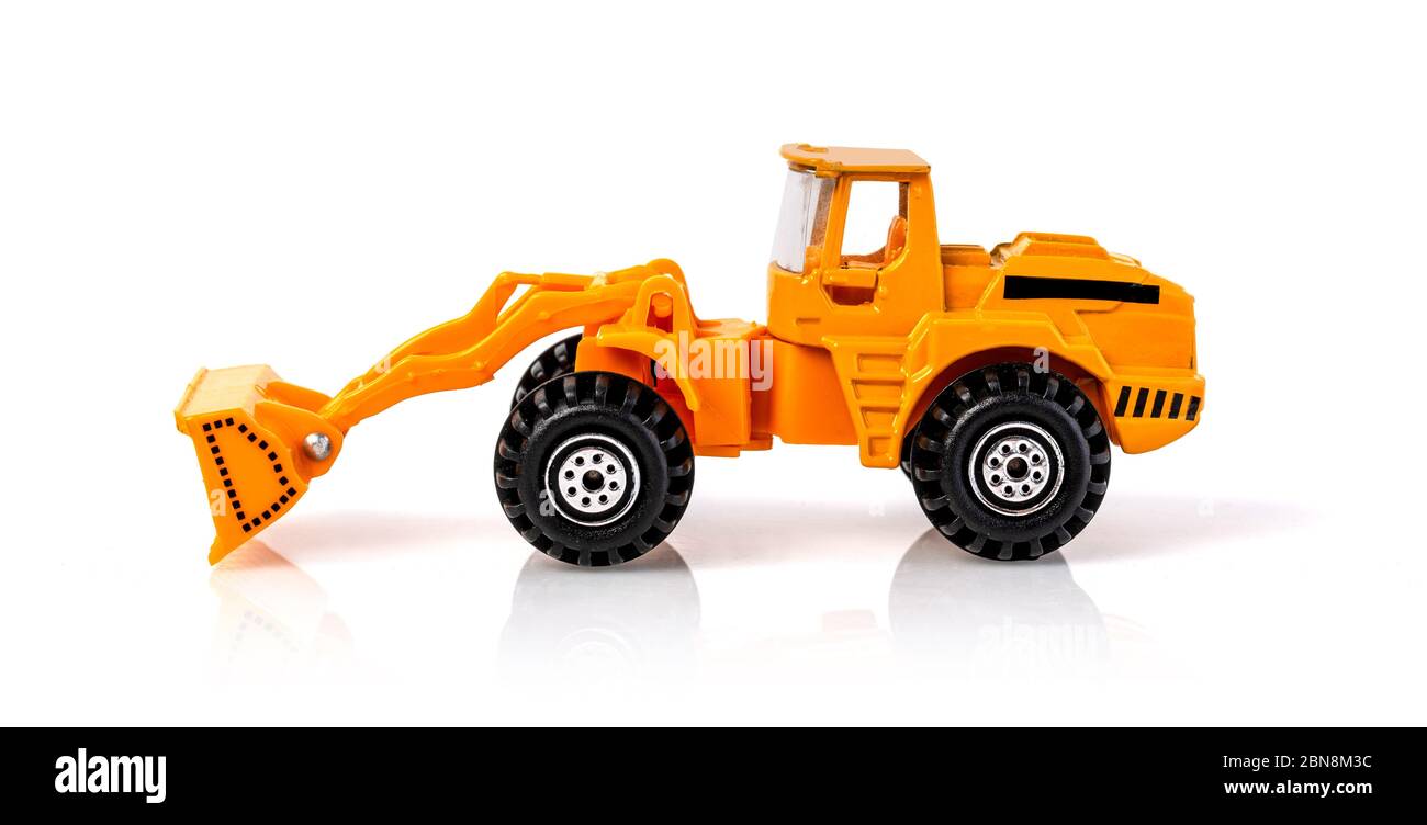 Ein Traktor oder Baggerlader für Erdarbeiten auf einer Baustelle, ein Miniatur-Frontlader eines Erdbewegungsmotors, ein Spielzeug Baggerlader, ein Spielzeug indu Stockfoto