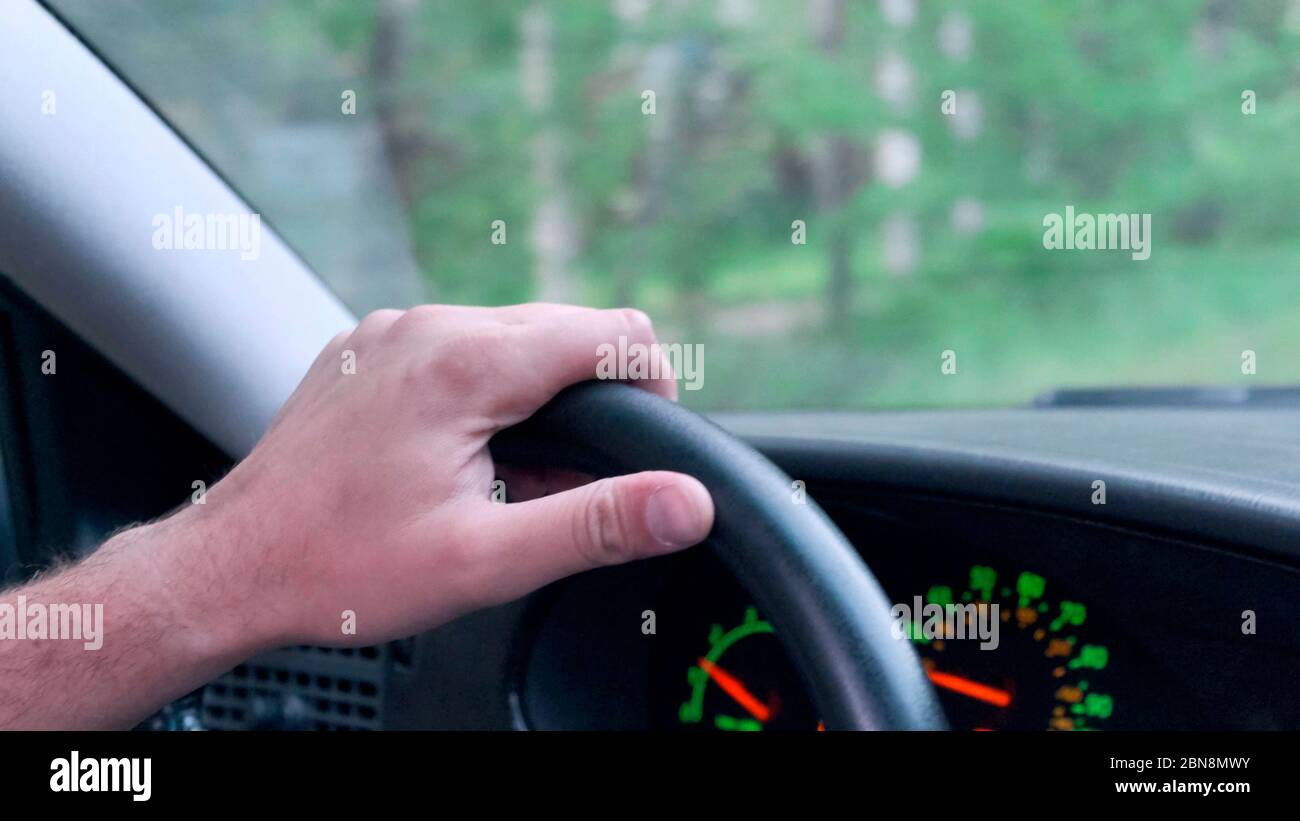 Die Person hält das Lenkrad des Fahrzeugs an. Autofahren. Stockfoto