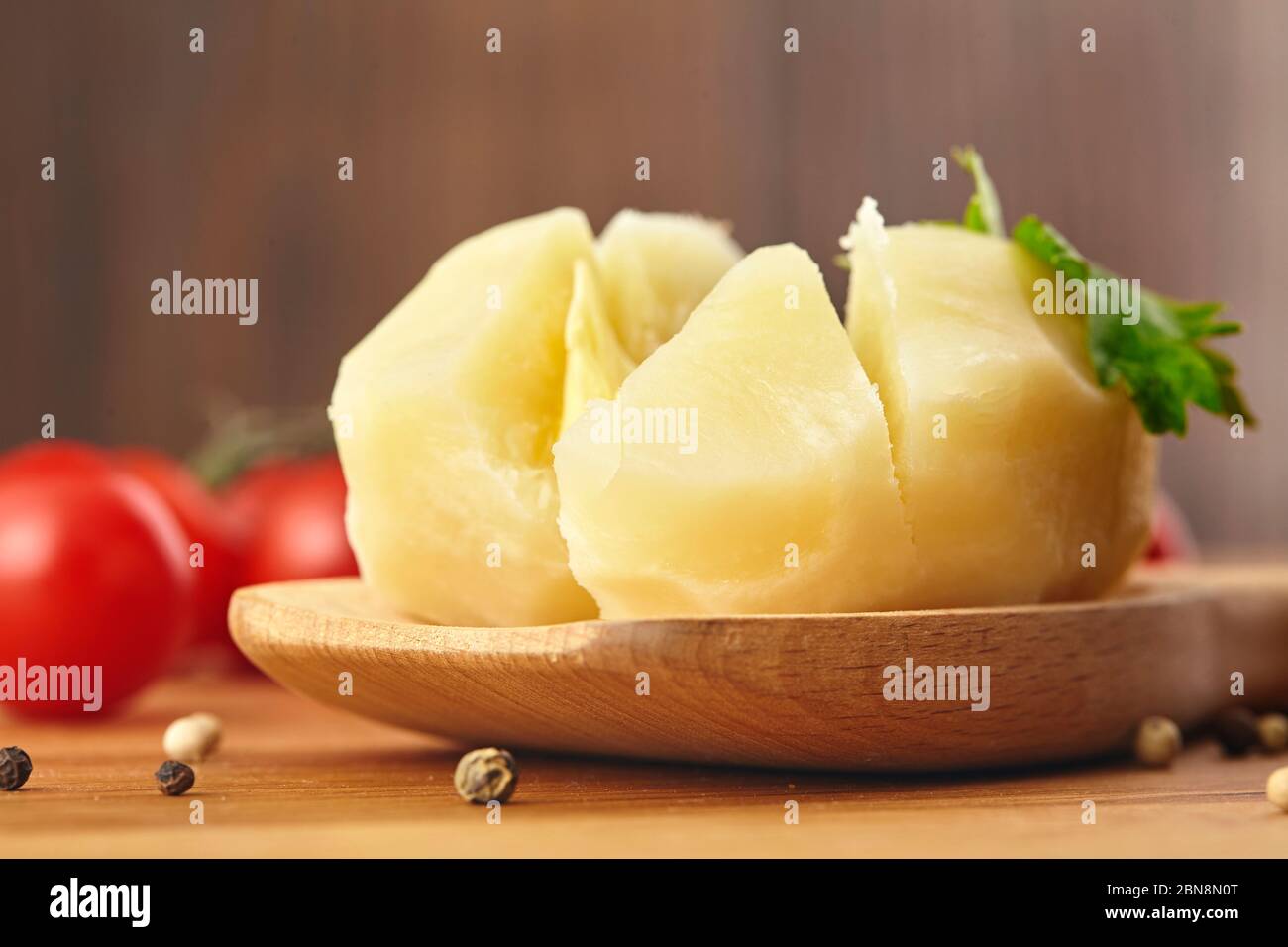 Gekochte Kartoffeln im Holzlöffel, Parsle Board Nahaufnahme Stockfoto