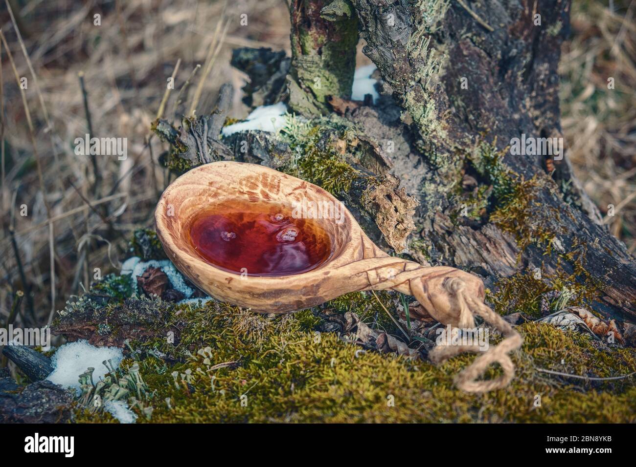 finnischer Holzbecher (kuksa) mit landschaftlich reizvoller Kulisse Stockfoto