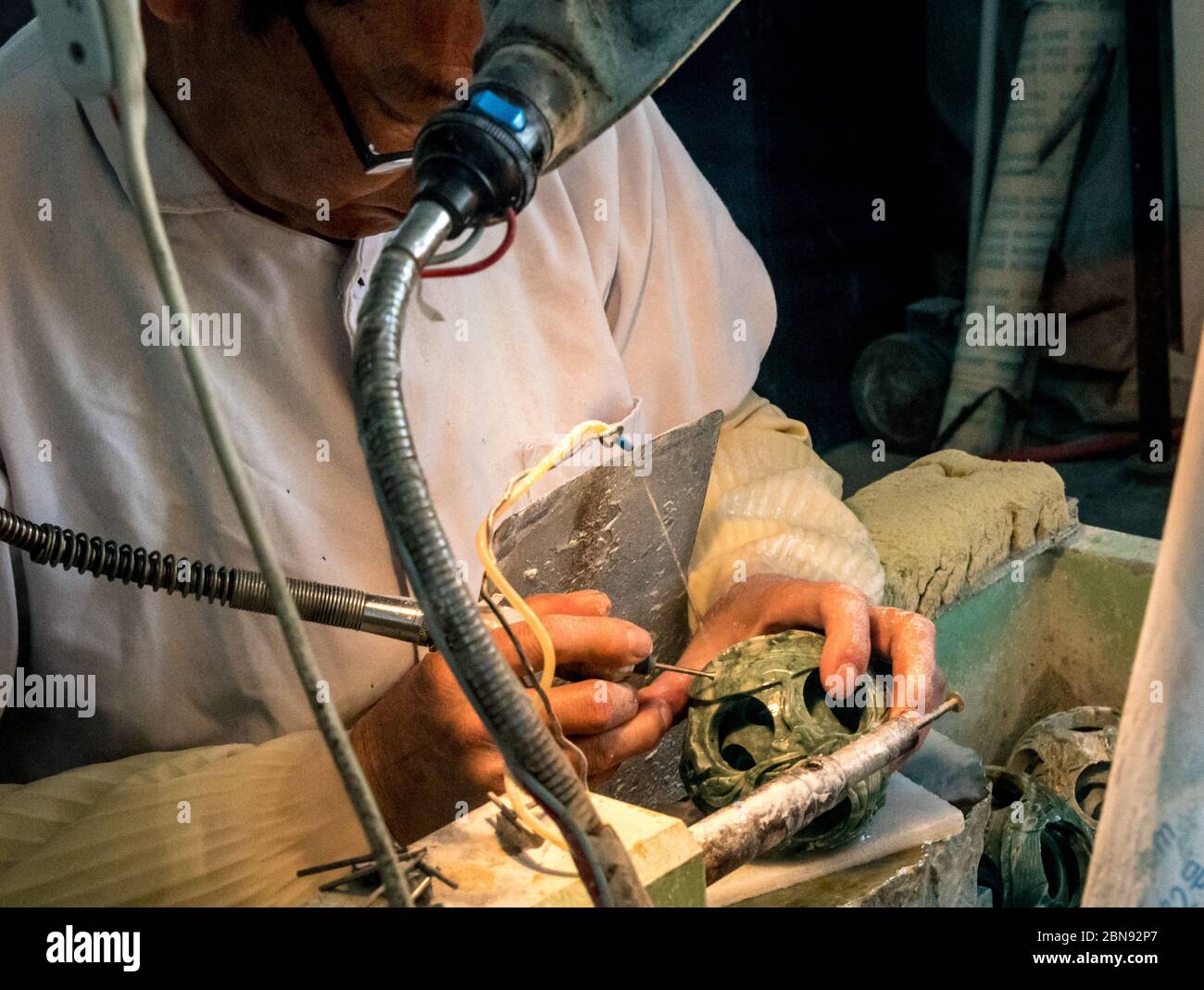 Handwerker, die 'Bälle in Kugeln' schnitzen, Jadefabrik in der Nähe von Badaling Stockfoto
