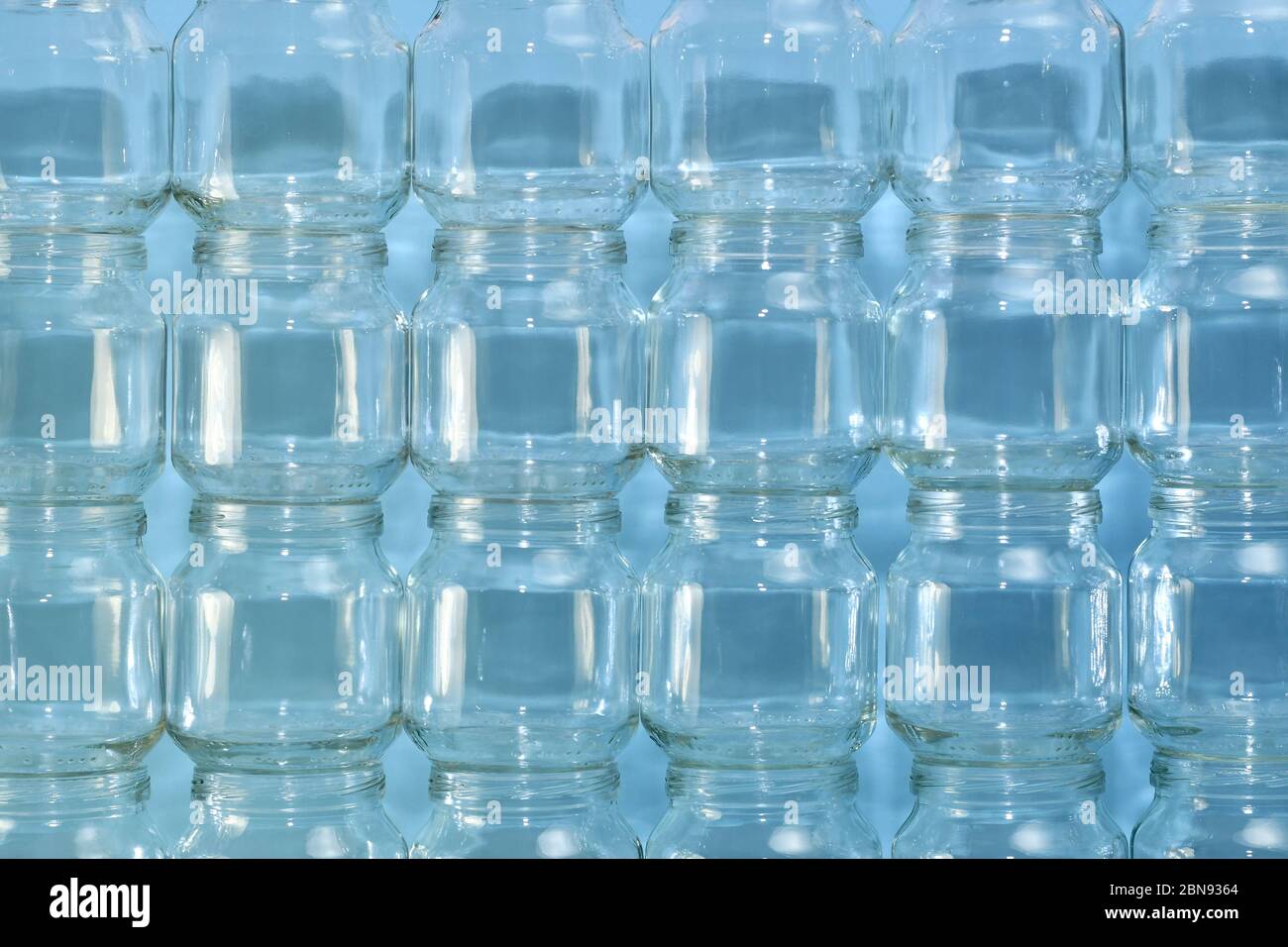 Der Hintergrund ist von der gebauten Wand aus transparenten kleinen Dosen, horizontal vergrößertes Fragment in der Mitte. Stockfoto