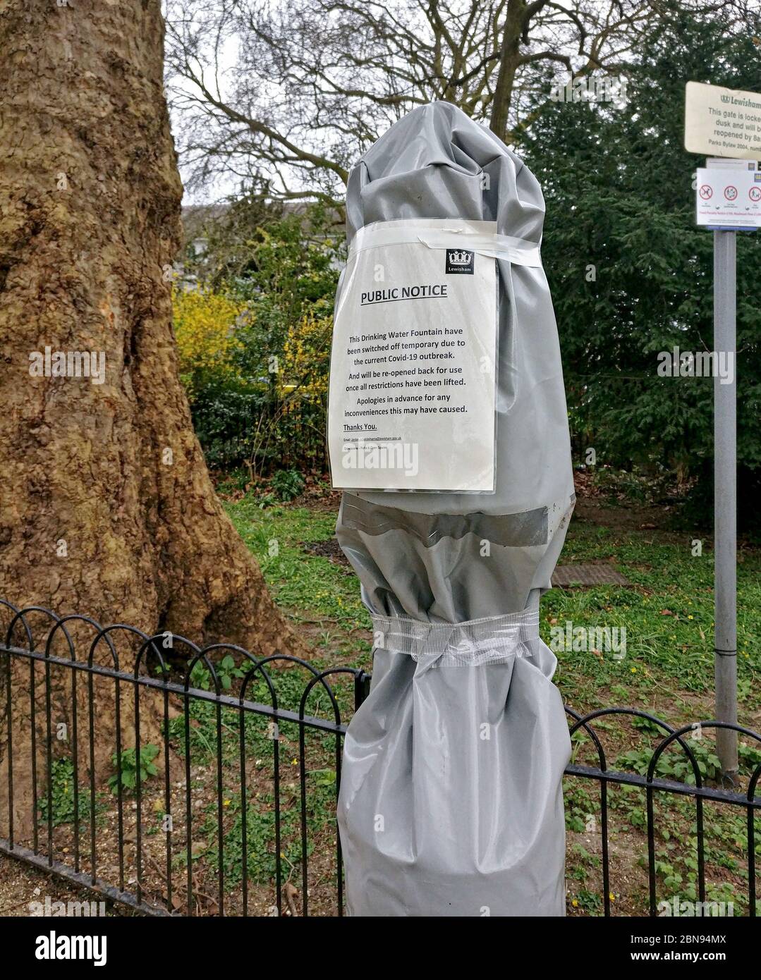 London, Großbritannien - 03. April 2020: Trinkbrunnen im Lewisham Park mit grauer Plastikfolie bedeckt, Schild mit Hinweis auf Schließung wegen Korona Stockfoto