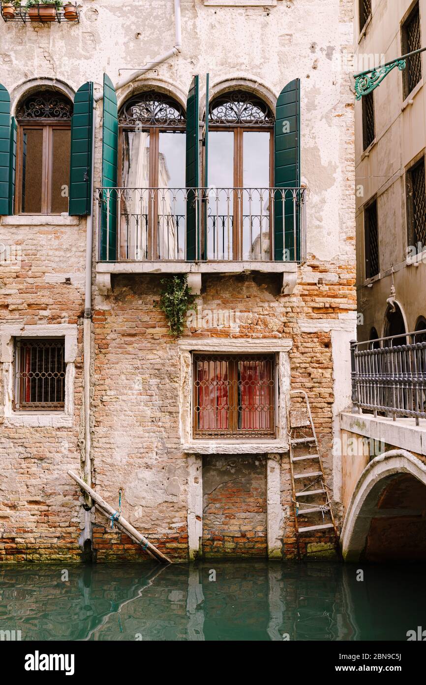 Nahaufnahmen von Fassaden in Venedig, Italien. Wunderschöne venezianische  Fenster mit offenen grünen Holzläden. Ein altes rotes Backsteinhaus neben  einer Brücke Stockfotografie - Alamy