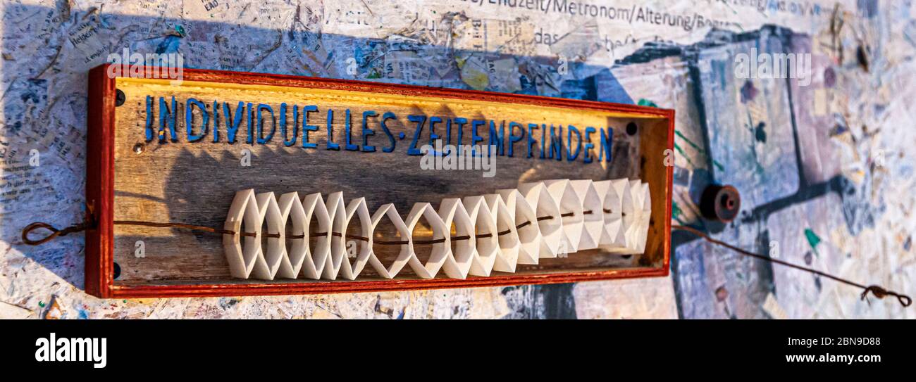 „Individual Sense of Time“ bezeichnet ein Kunstwerk, das in einer Kiste aufgehängt ist, als eine Konzertina. Individuelles Zeitgefühl. Kunstwerk von Stoi in Grevenbroich, Deutschland Stockfoto