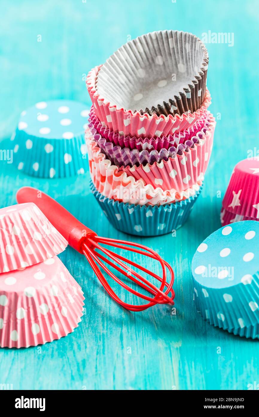 Variation von kleinen Papierformen zum Backen von Cupcakes und Muffins mit Kiss. Bunte Papierauslagen. Stockfoto