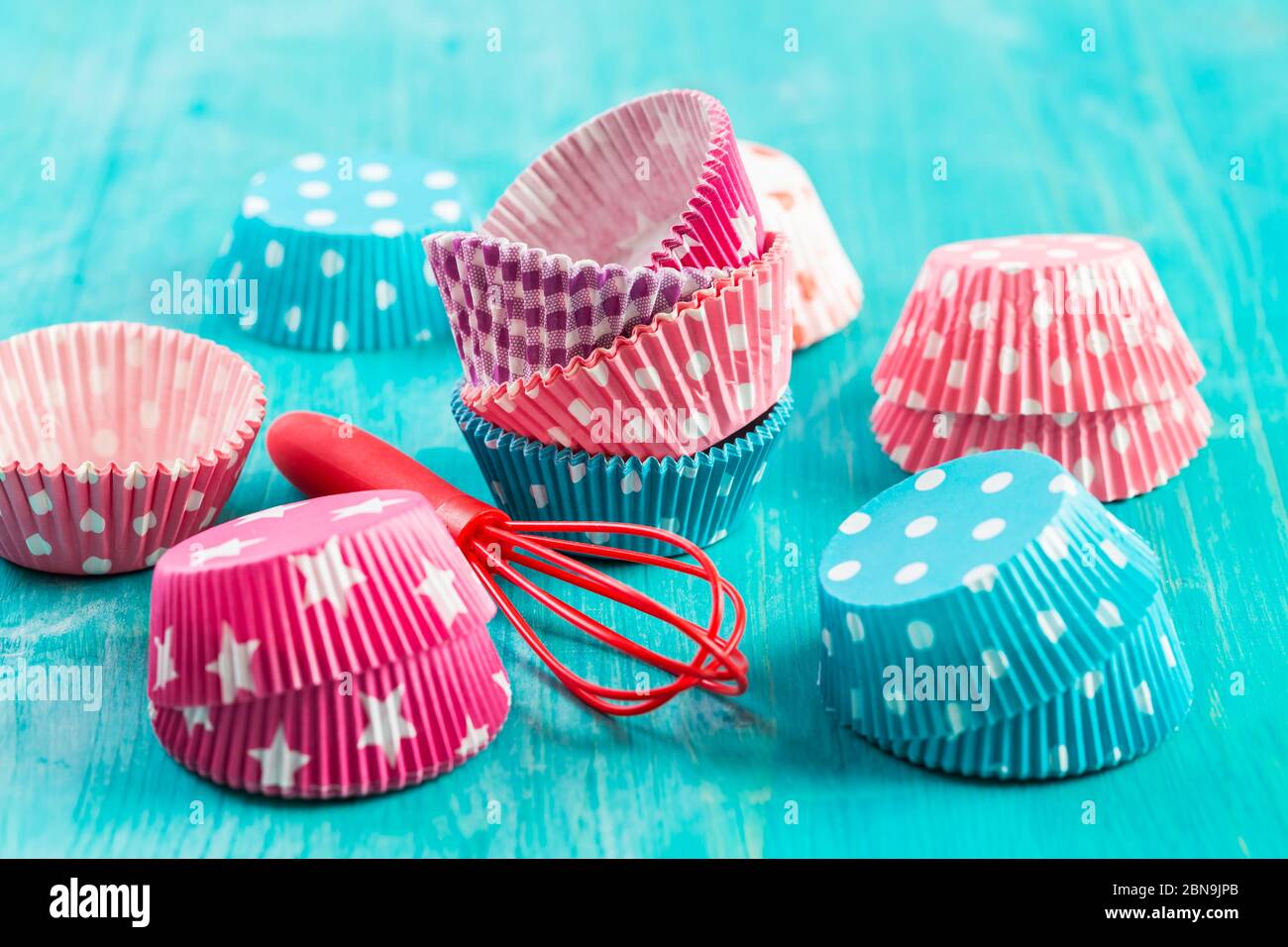 Variation von kleinen Papierformen zum Backen von Cupcakes und Muffins mit Kiss. Bunte Papierauslagen. Stockfoto