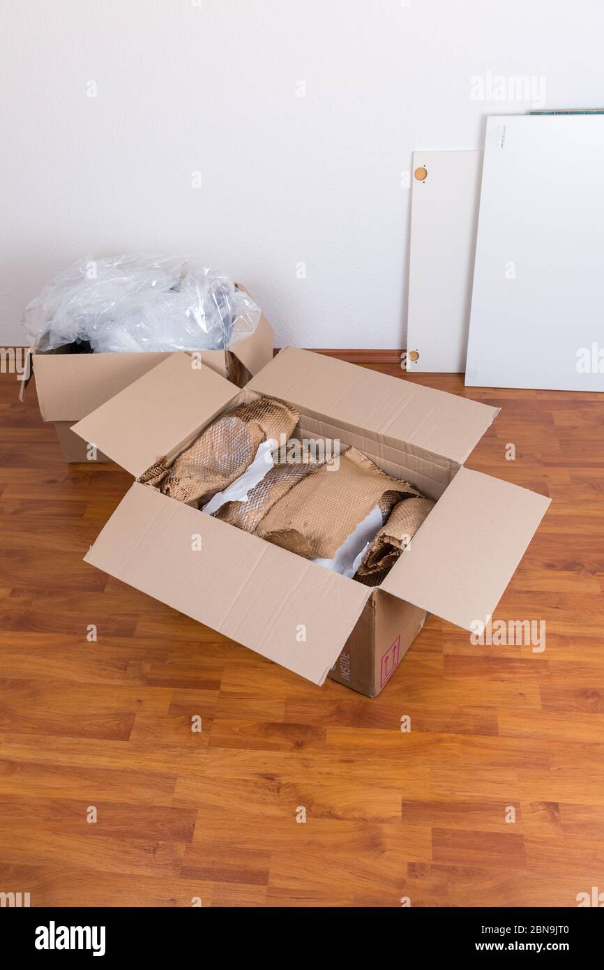 Transportboxen mit Verpackungsmaterial für empfindliche Gegenstände auf dem Boden. Konzept des ein- und Ausfahrens. Stockfoto