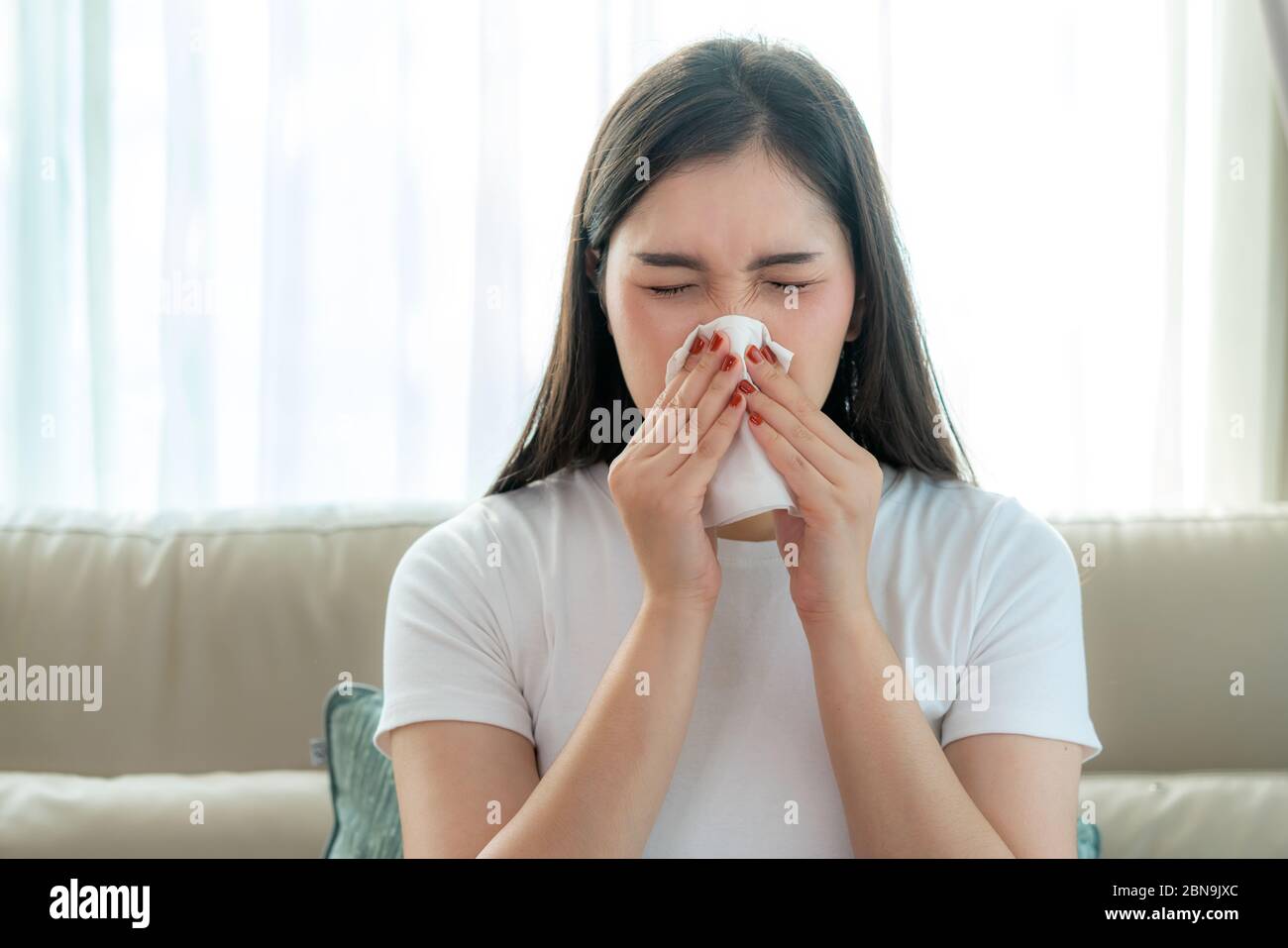 Asian Woman krank und traurig mit Niesen an der Nase und kaltem Husten auf Gewebepapier, weil Influenza und schwache oder Virusbakterien von Staubwetter oder Rauch Stockfoto