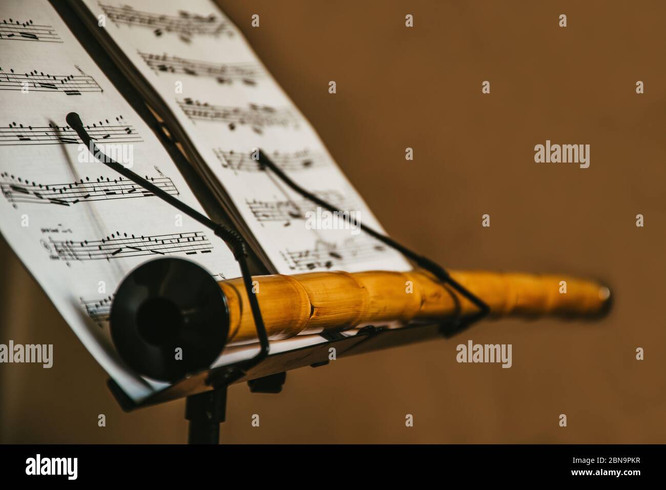 Ein orientalisches Musikinstrument Ney, bleibt auf dem Notenständer mit Noten, isolierter, mystischer Szene, traditionellen türkischen Musikmaterialien, Nahaufnahme Stockfoto