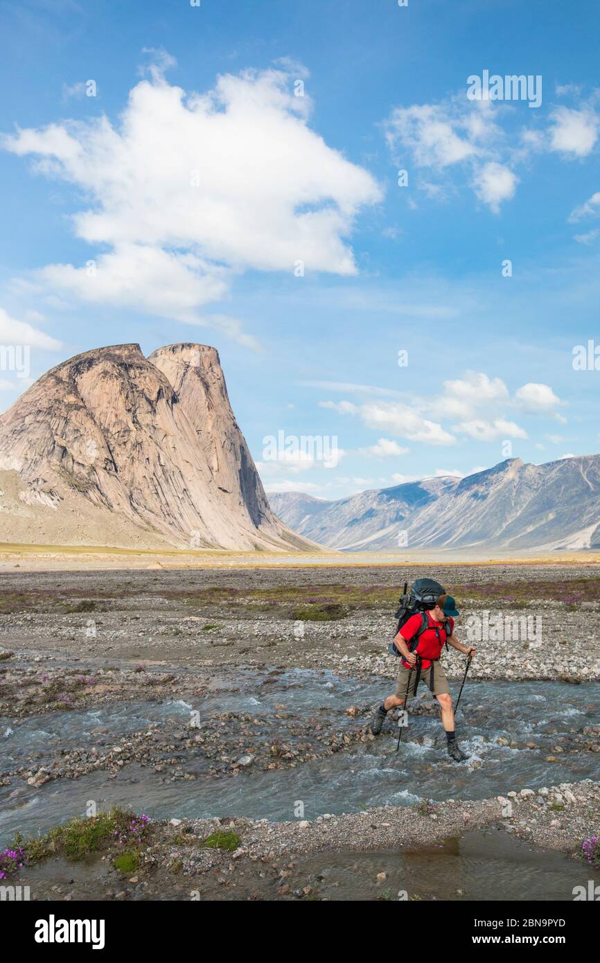 Wanderer überquert Fluss in Akshayak Pass. Stockfoto