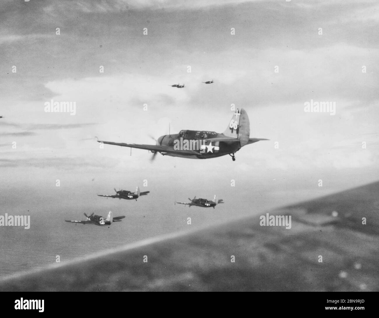 Curtiss SB2C-3 Bomber von VB-18 auf Patrouille über der philippinischen See, 15. November 1944. Sie stammen von USS Intrepid (CV-11). Beachten Sie grob neu lackierte Markierungen auf den Schwänzen. Stockfoto