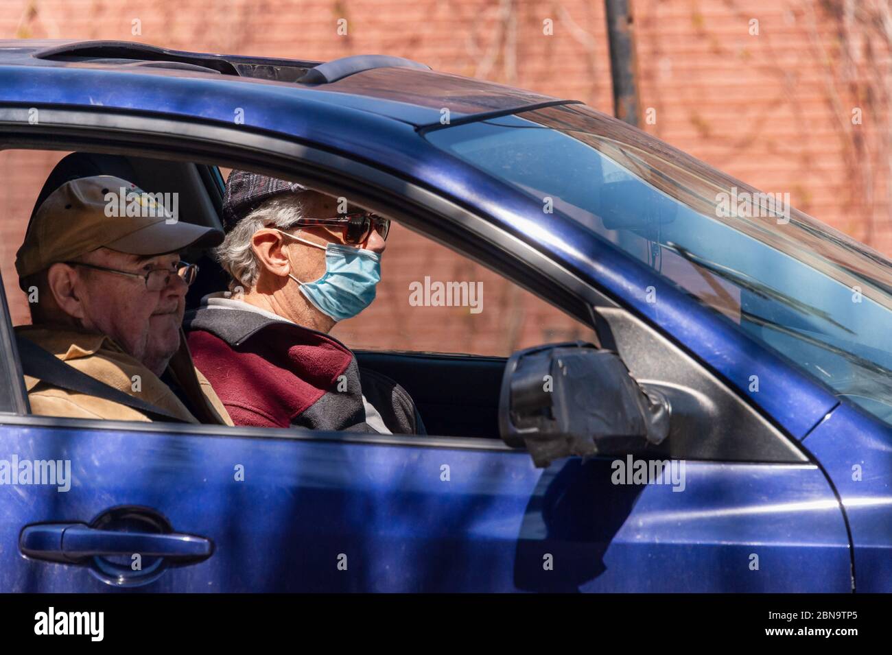 Montreal, CA - 13. Mai 2020: Mann mit Gesichtsmaske zum Schutz vor COVID-19 fährt sein Auto Stockfoto