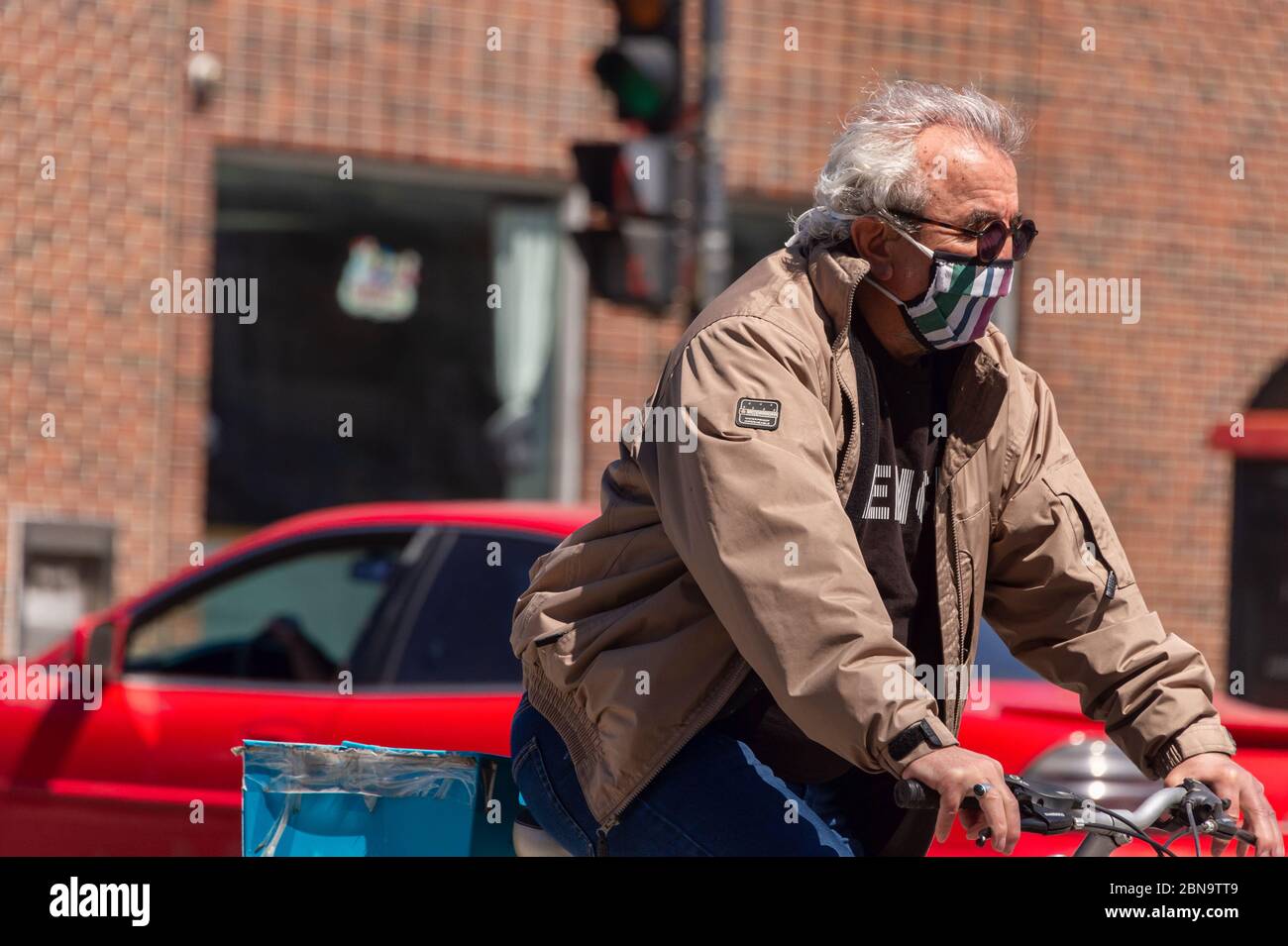 Montreal, CA - 13. Mai 2020: Ein Mann mit Gesichtsmaske fährt während der COVID-19-Pandemie mit dem Fahrrad. Stockfoto