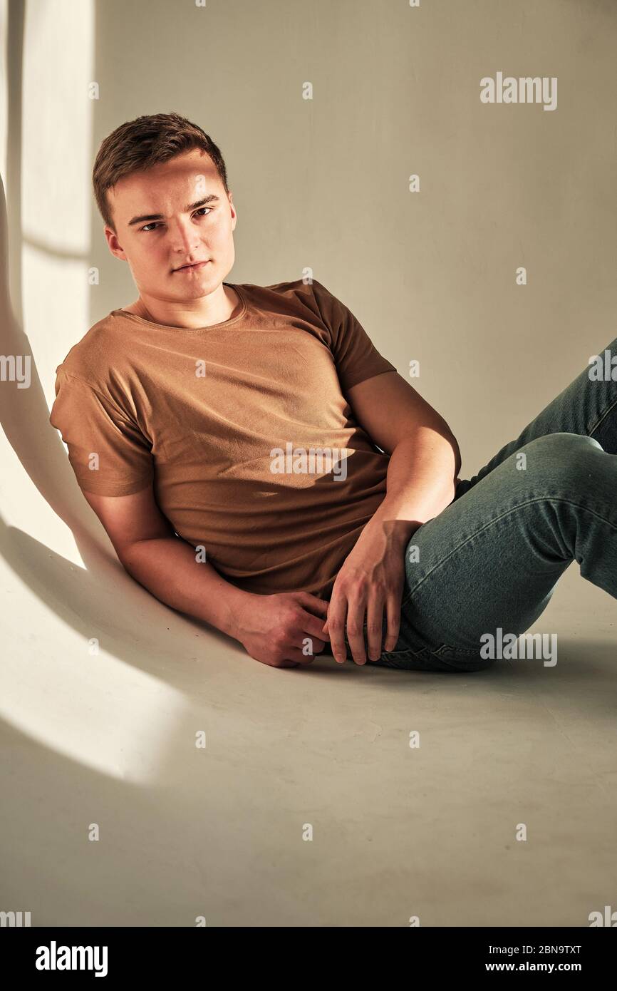Schöner junger Mann allein in T-Shirt und Jeans Stockfoto