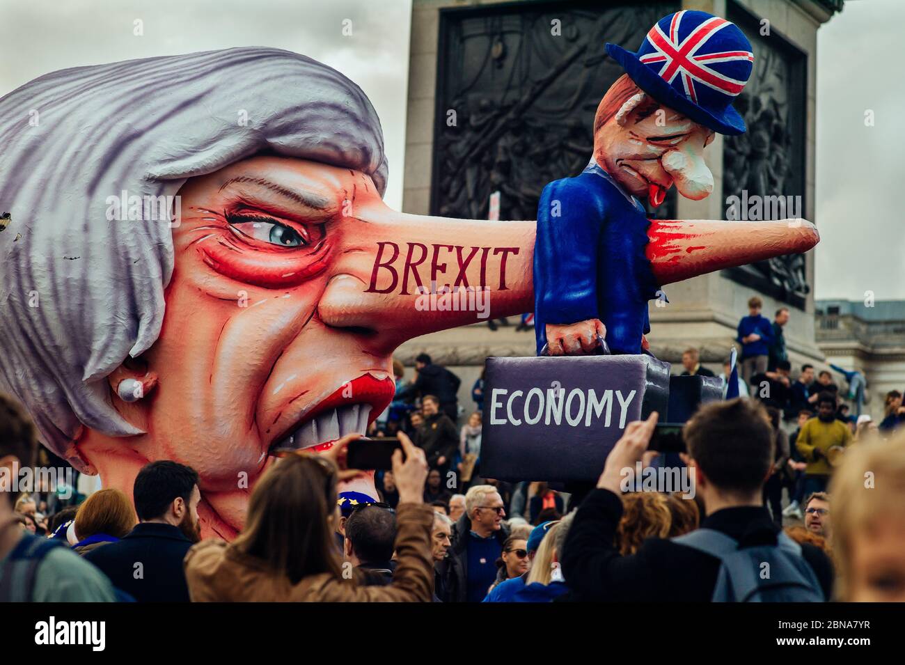 LONDON, GROSSBRITANNIEN - 23. März 2019: Eine riesige Figur von Theresa May treibt einen kleinen Mann, der die britische Wirtschaft bei der größten Anti-brexit-Kampagne repräsentiert, in die Höhe Stockfoto