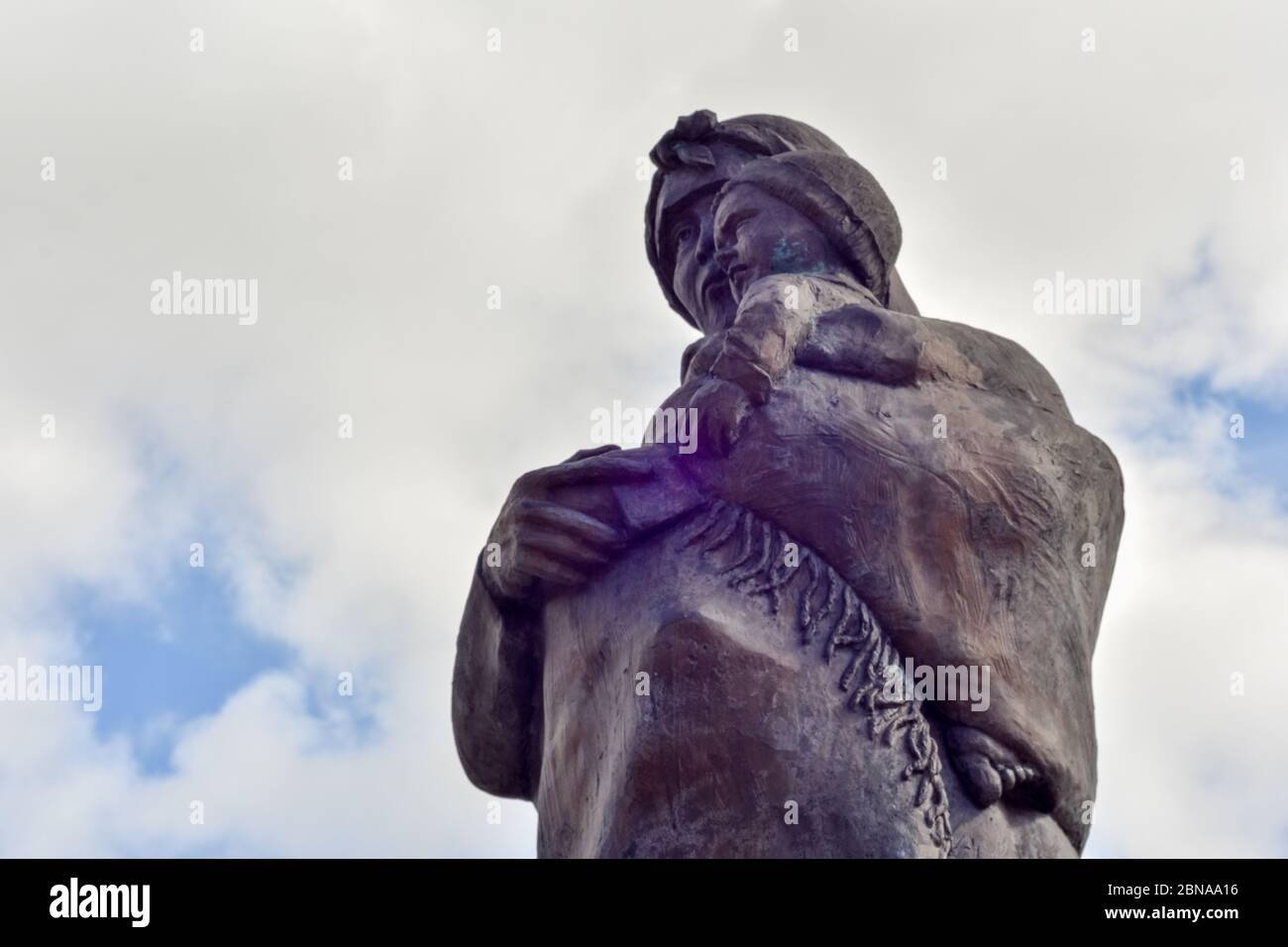 Low-Angle-Aufnahme einer schönen Statue einer Mutter Hält ihr Kind unter dem blauen Himmel Stockfoto