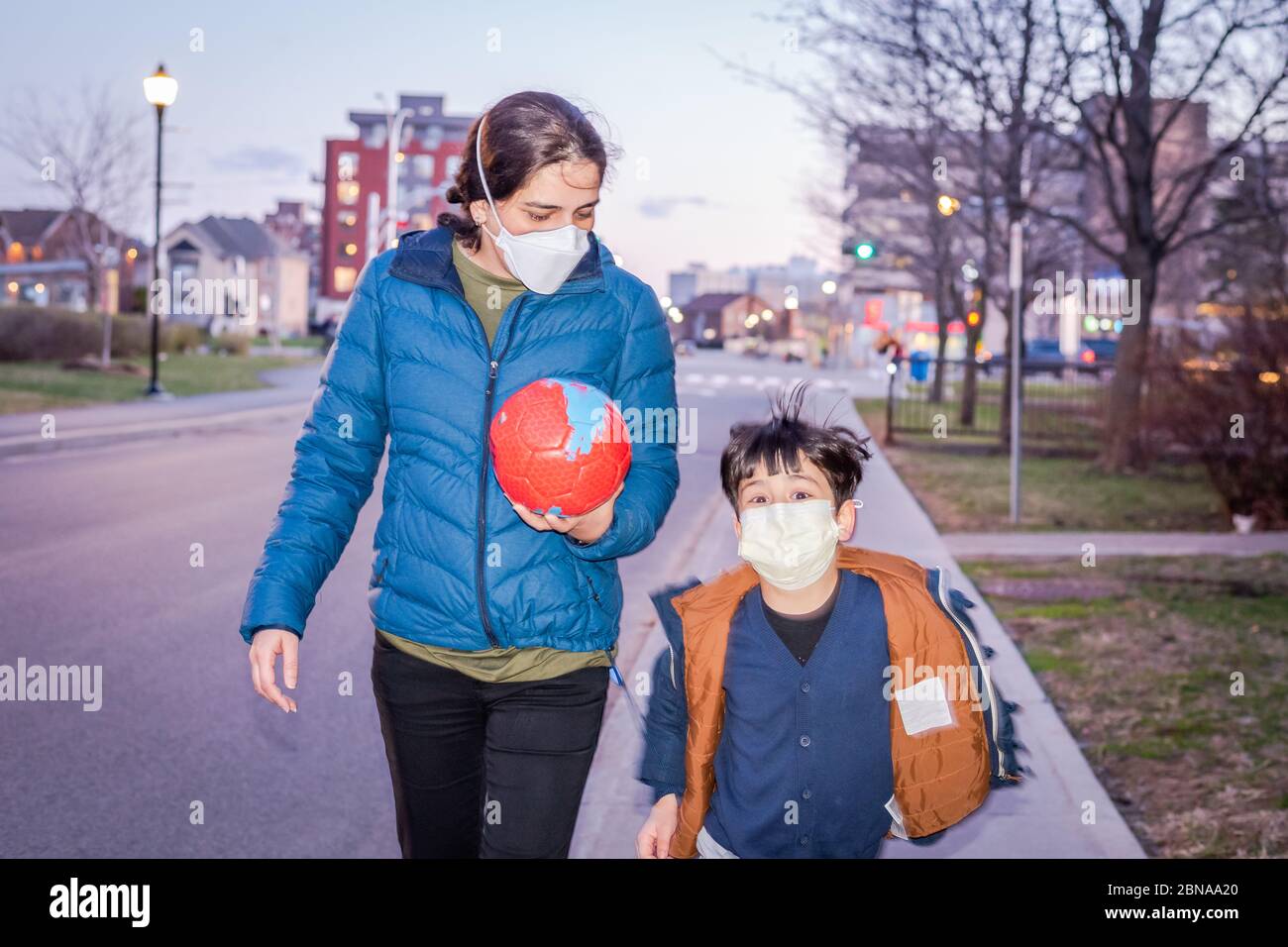 Novel Coronavirus COVID-19 verändert unser Leben in der Gesellschaft, Mutter und Sohn gehen auf den Boden mit Gesichtsmaske zu spielen Stockfoto