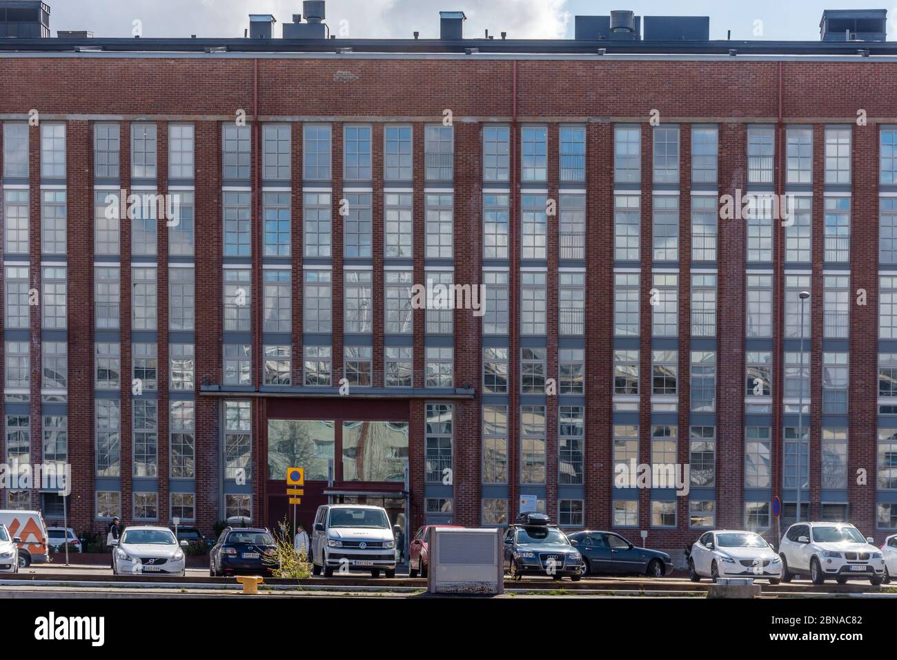 Altes rotes Ziegelgebäude mit vielen Fenstern am Aurajoki Fluss in Turku Finnland Stockfoto