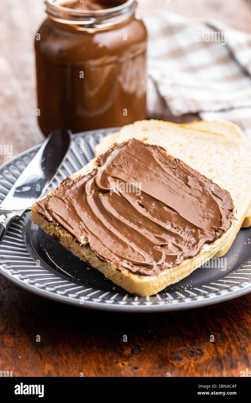 Toast Brot mit Haselnuss-Aufstrich. Süße Schokoladencreme auf dem Teller. Stockfoto