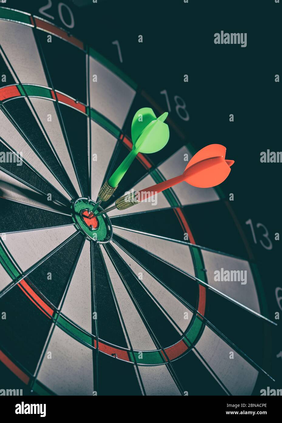 Auf den Punkt, Ziel-Zentrum, Bullseye-Konzept. Grüne und rote Darts, erfolgreiche Missionen in Strategie basiert, schwarzer Hintergrund, vertikales Porträt. Stockfoto