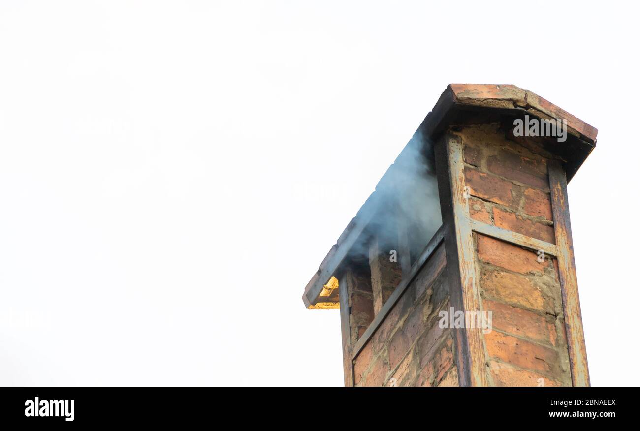 Rauch vom Kamin auf dem Dach des Hauses Stockfoto