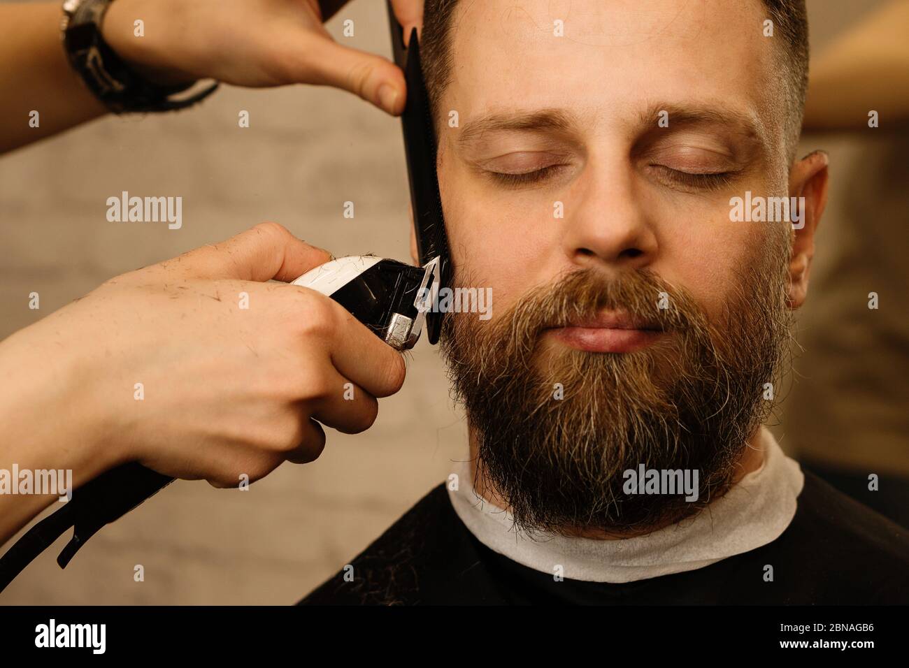 Barbier Trimmen Bart des männlichen Kunden mit Rasierer in Barbershop. Mann mit Bart und Schnurrbart immer stilvolle trendige Haarrasur, mit Haarschneider und Kamm. Nahaufnahme Stockfotografie - Alamy