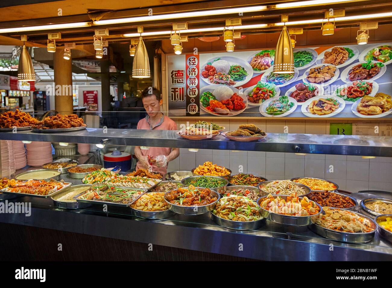Eine Auswahl an frisch zubereiteten asiatischen Gerichten in einem Händlerstand im Lau Pa Sat Hawker Center, Singapur. Stockfoto
