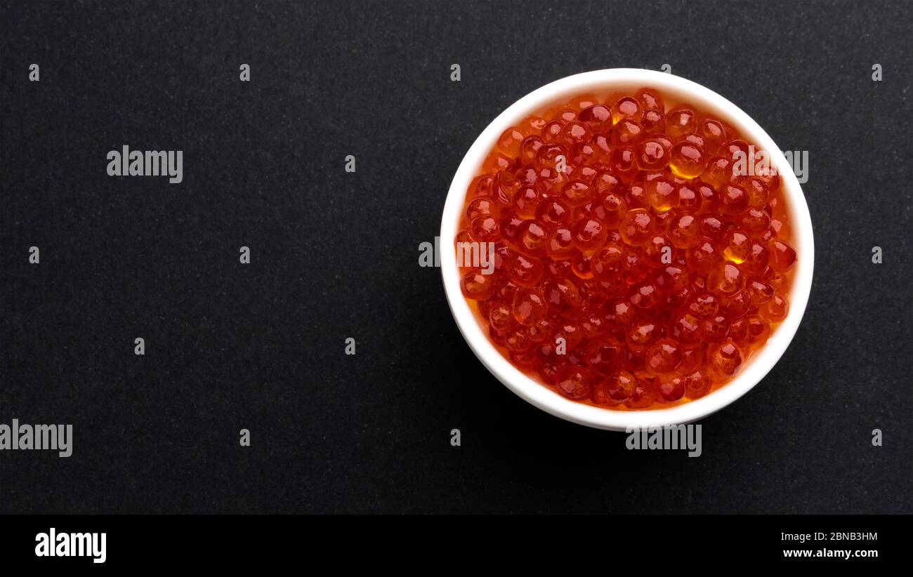 Roter Kaviar auf schwarzem Steingrund mit Kopierraum, Draufsicht Stockfoto