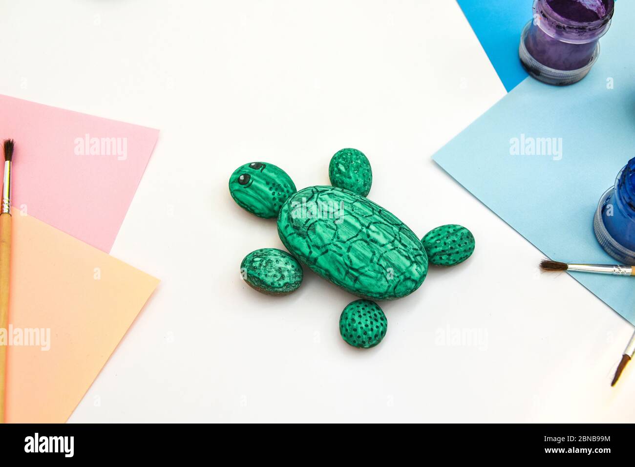 Schritt für Schritt eine Steinschildkröte auf einem Stein malen. Kinder Kunstprojekt. DIY-Konzept. Schritt für Schritt Fotoanleitung. Stockfoto