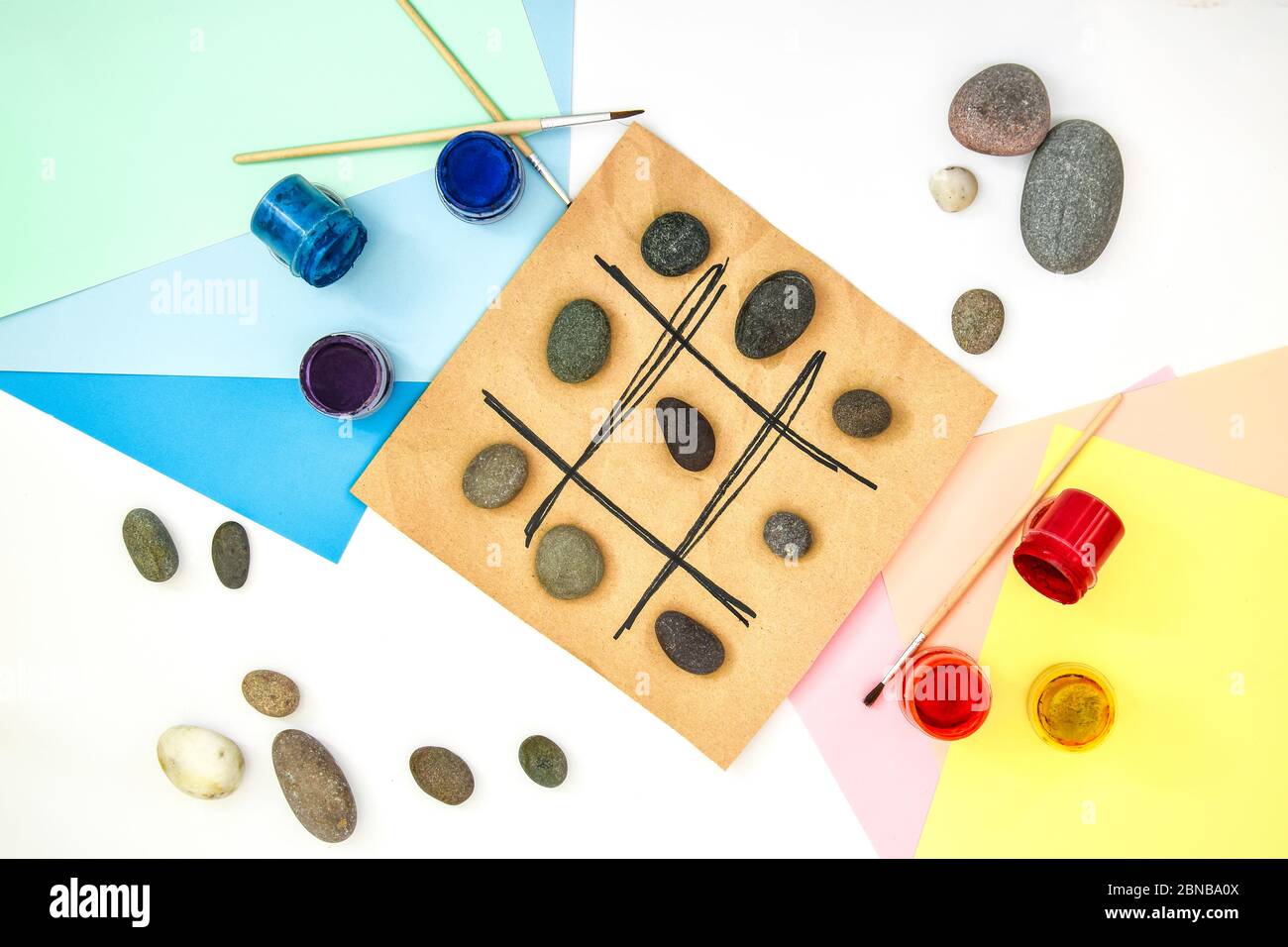Draufsicht der Tic tac Zehen Spiel mit Steinen mit Naughts und Kreuze markiert. Kinder Kunstprojekt, ein Handwerk für Kinder. DIY-Konzept. Schritt für Schritt Stockfoto