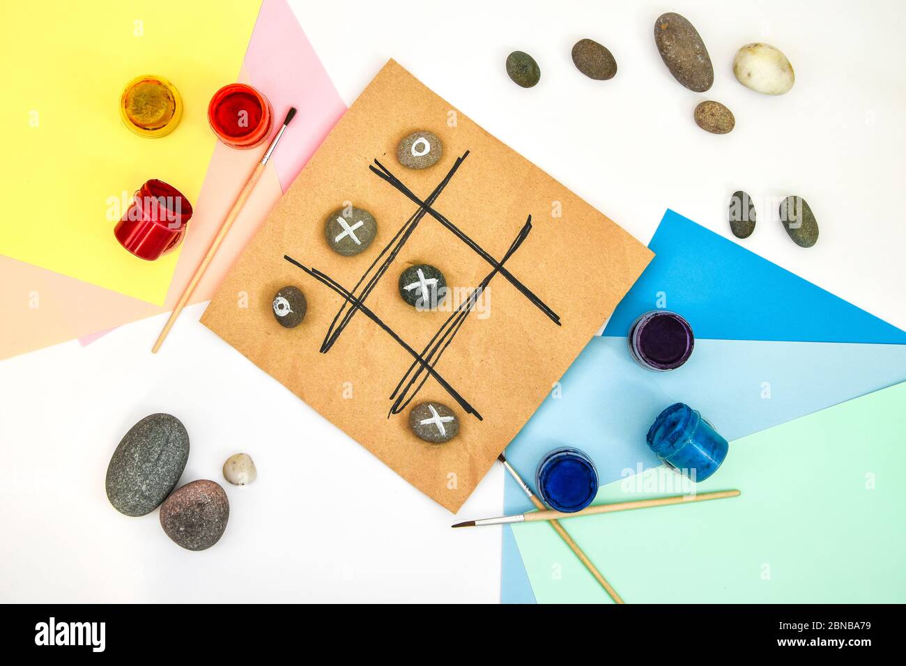 Draufsicht der Tic tac Zehen Spiel mit Steinen mit Naughts und Kreuze markiert. Kinder Kunstprojekt, ein Handwerk für Kinder. DIY-Konzept. Schritt für Schritt. Stockfoto